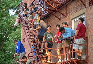 Students gathering on a fire escape to chat. Links to Gifts of Cash, Checks, and Credit Cards