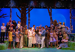 Students gather on stage during a play. Links to Beneficiary Designations