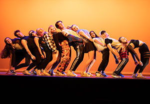 A group of actors leaning backwards together. Links to Gifts by Estate Note