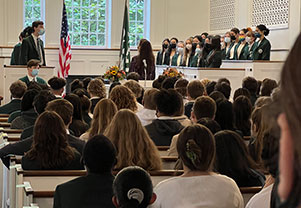 Students gather to watch a debate. Links to What to Give