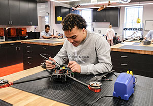 A student works on a drone. Links to Gifts by Will